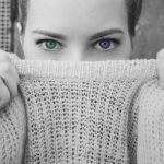 Женское лицо, наполовину закрытое воротником свитера. фото