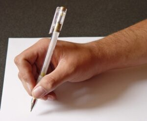 Рука с авторучкой лежит на листе бумаги. фото