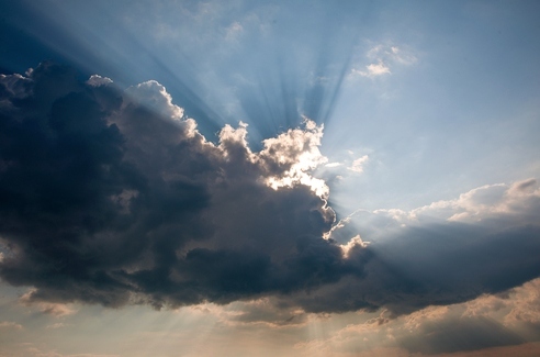 Через кучевые облака пробивается солнечный свет. фото