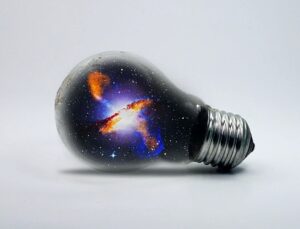 Лампочка с нарисованной галактикой. иллюстрация