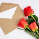 Три красные розы и карточка в конверте. фото