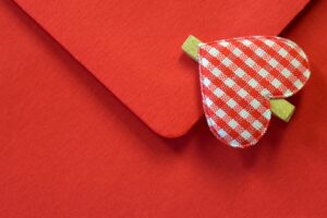 К красному конверту прицеплен декор для Дня Валентина. иллюстрация